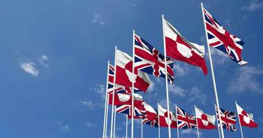 Greenland and United Kingdom Flags Waving Together in the Sky, Seamless Loop in Wind, Space on Left Side for Design or Information, 3D Rendering video