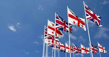 Georgia and United Kingdom Flags Waving Together in the Sky, Seamless Loop in Wind, Space on Left Side for Design or Information, 3D Rendering video