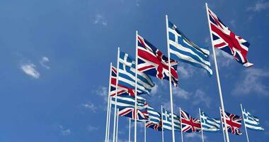 Greece and United Kingdom Flags Waving Together in the Sky, Seamless Loop in Wind, Space on Left Side for Design or Information, 3D Rendering video