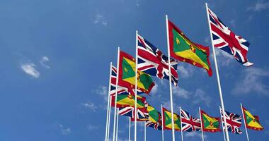 Grenada en Verenigde koninkrijk vlaggen golvend samen in de lucht, naadloos lus in wind, ruimte Aan links kant voor ontwerp of informatie, 3d renderen video
