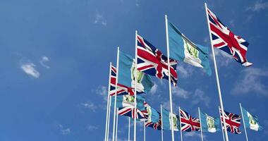 Guatemala and United Kingdom Flags Waving Together in the Sky, Seamless Loop in Wind, Space on Left Side for Design or Information, 3D Rendering video