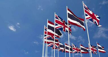 Thailand and United Kingdom Flags Waving Together in the Sky, Seamless Loop in Wind, Space on Left Side for Design or Information, 3D Rendering video