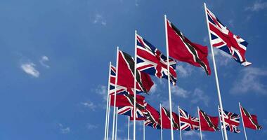 Trinidad and Tobago and United Kingdom Flags Waving Together in the Sky, Seamless Loop in Wind, Space on Left Side for Design or Information, 3D Rendering video