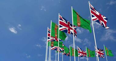 Turkmenistan and United Kingdom Flags Waving Together in the Sky, Seamless Loop in Wind, Space on Left Side for Design or Information, 3D Rendering video