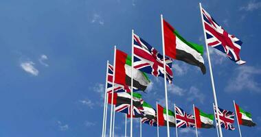 United Arab Emirates and United Kingdom Flags Waving Together in the Sky, Seamless Loop in Wind, Space on Left Side for Design or Information, 3D Rendering video