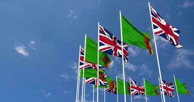 Zambia and United Kingdom Flags Waving Together in the Sky, Seamless Loop in Wind, Space on Left Side for Design or Information, 3D Rendering video