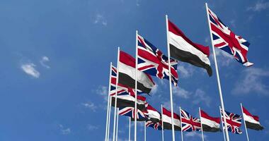 Yemen and United Kingdom Flags Waving Together in the Sky, Seamless Loop in Wind, Space on Left Side for Design or Information, 3D Rendering video