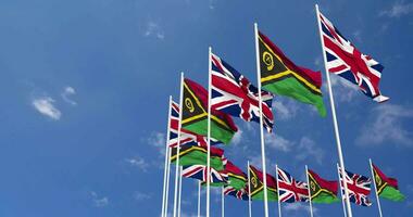 Vanuatu et uni Royaume drapeaux agitant ensemble dans le ciel, sans couture boucle dans vent, espace sur la gauche côté pour conception ou information, 3d le rendu video