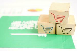 Online shopping, Shopping cart box on Saudi Arabia flag, import export, finance commerce. photo