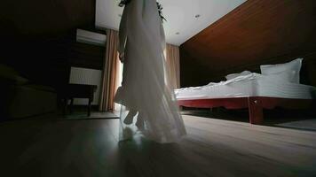 Bride's Graceful Footsteps. The elegant stride of a bride in her gown, captured in a room with morning lighting. The morning of the bride running to the window. video