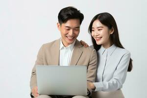 AI generated happy young Asian co worker holding and looking at laptop on white isolated background photo