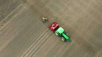 aérien vue de tracteur avec semoir dans champ. de haut en bas vue de une tracteur avec une semoir attachement en train de préparer le champ pour plantation. video