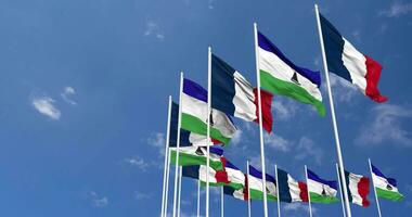 Lesotho and France Flags Waving Together in the Sky, Seamless Loop in Wind, Space on Left Side for Design or Information, 3D Rendering video