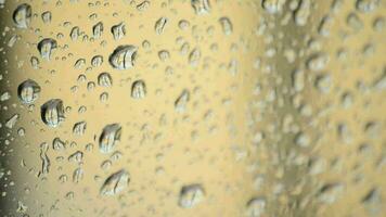 gotas de lluvia corredizo y que cae en el vaso de un ventana un lloviendo día video