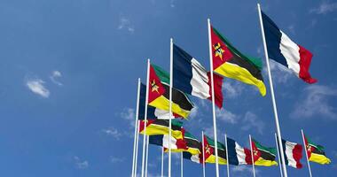 Mozambique and France Flags Waving Together in the Sky, Seamless Loop in Wind, Space on Left Side for Design or Information, 3D Rendering video