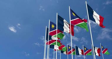 Namíbia e França bandeiras acenando juntos dentro a céu, desatado ciclo dentro vento, espaço em esquerda lado para Projeto ou Informação, 3d Renderização video