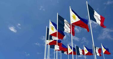 philippines et France drapeaux agitant ensemble dans le ciel, sans couture boucle dans vent, espace sur la gauche côté pour conception ou information, 3d le rendu video