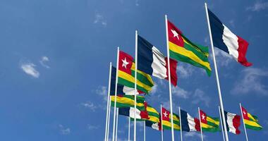 Togo and France Flags Waving Together in the Sky, Seamless Loop in Wind, Space on Left Side for Design or Information, 3D Rendering video