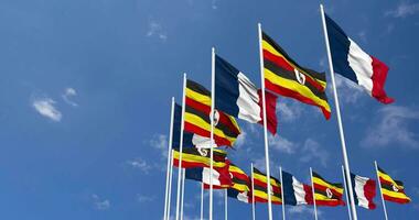 Uganda e Francia bandiere agitando insieme nel il cielo, senza soluzione di continuità ciclo continuo nel vento, spazio su sinistra lato per design o informazione, 3d interpretazione video