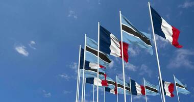 botswana och Frankrike flaggor vinka tillsammans i de himmel, sömlös slinga i vind, Plats på vänster sida för design eller information, 3d tolkning video