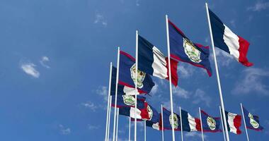 Belize et France drapeaux agitant ensemble dans le ciel, sans couture boucle dans vent, espace sur la gauche côté pour conception ou information, 3d le rendu video