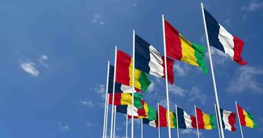 Guinea and France Flags Waving Together in the Sky, Seamless Loop in Wind, Space on Left Side for Design or Information, 3D Rendering video