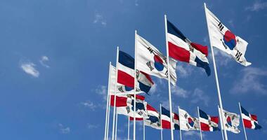 dominikanisch Republik und Süd Korea Flaggen winken zusammen im das Himmel, nahtlos Schleife im Wind, Raum auf links Seite zum Design oder Information, 3d Rendern video