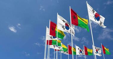 Guinea bissau e Sud Corea bandiere agitando insieme nel il cielo, senza soluzione di continuità ciclo continuo nel vento, spazio su sinistra lato per design o informazione, 3d interpretazione video