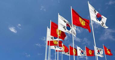 Kyrgyzstan e Sud Corea bandiere agitando insieme nel il cielo, senza soluzione di continuità ciclo continuo nel vento, spazio su sinistra lato per design o informazione, 3d interpretazione video