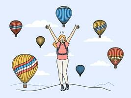 Woman traveler stands among rising balloons and joyfully raises hands up enjoying trip to festival vector