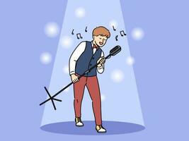 Talented boy singer holds professional microphone on tripod standing in light of spotlight vector