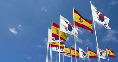 Spagna e Sud Corea bandiere agitando insieme nel il cielo, senza soluzione di continuità ciclo continuo nel vento, spazio su sinistra lato per design o informazione, 3d interpretazione video
