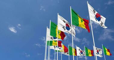 Senegal und Süd Korea Flaggen winken zusammen im das Himmel, nahtlos Schleife im Wind, Raum auf links Seite zum Design oder Information, 3d Rendern video