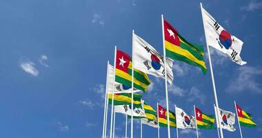 Togo and South Korea Flags Waving Together in the Sky, Seamless Loop in Wind, Space on Left Side for Design or Information, 3D Rendering video