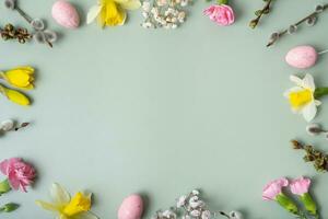 Spring flowers ans easter eggs border on green background with copy space. Easter greeting card template photo