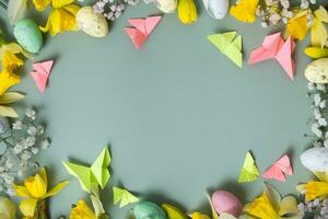 Spring flowers ans easter eggs border on green background with copy space. Easter greeting card template photo