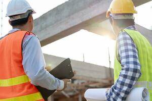 los ingenieros utilizan la construcción de verificación de planos en el sitio. construcción de inspección de contratistas e inspectores durante el control de calidad del control de forma civil del proyecto. auditar, inspeccionar, controlar la calidad. foto