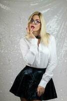 blonde woman wearing glasses and an black leather skirt photo