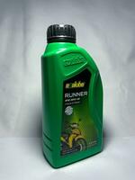 Surakarta, Indonesia, 2023 - Evalube Runner motor oil, high quality motorcycle oil four stroke 4T 800ml. Evalube green bottle packaging. photo