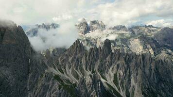 antenn se av cadini di misurina bergen med Tre cime di lavaredo bergen i de bakgrund under en solig dag med några moln. dolomiterna, Italien. dramatisk och filmiska landskap. video