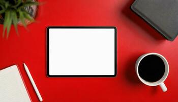 AI Generated Top view of a red work surface with mockup tablet, plant, coffee and pen photo