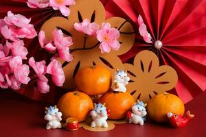 Chinese New Year of the dragon festival concept. Mandarin orange, red envelopes, dragon and gold ingot with red paper fans. Traditional holiday lunar New Year. photo