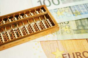 Gold abacus on banknote money, finance trading investment business currency concept. photo