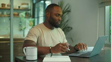 African American man wearing casual clothes working in his home video