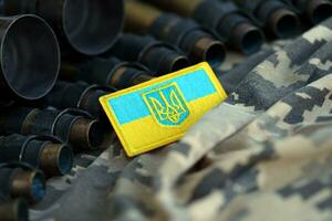 Ukrainian symbol on machine gun belt lies on ukrainian pixeled military camouflage photo
