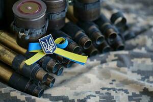 Ukrainian symbol on machine gun belt lies on ukrainian pixeled military camouflage photo