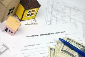 Residential construction agreement ready to sign with small toy houses and pen. Construction contract photo