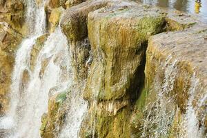 Beautiful waterfall between large rocks in autumn forest. Sofievskiy park in Uman, Ukraine photo