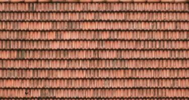 Close up of red terracotta roof shingles with some mildew. Background texture of roofing material photo