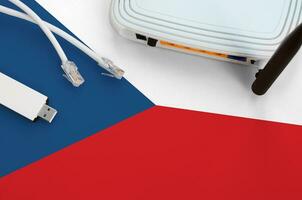 Czech flag depicted on table with internet rj45 cable, wireless usb wifi adapter and router. Internet connection concept photo